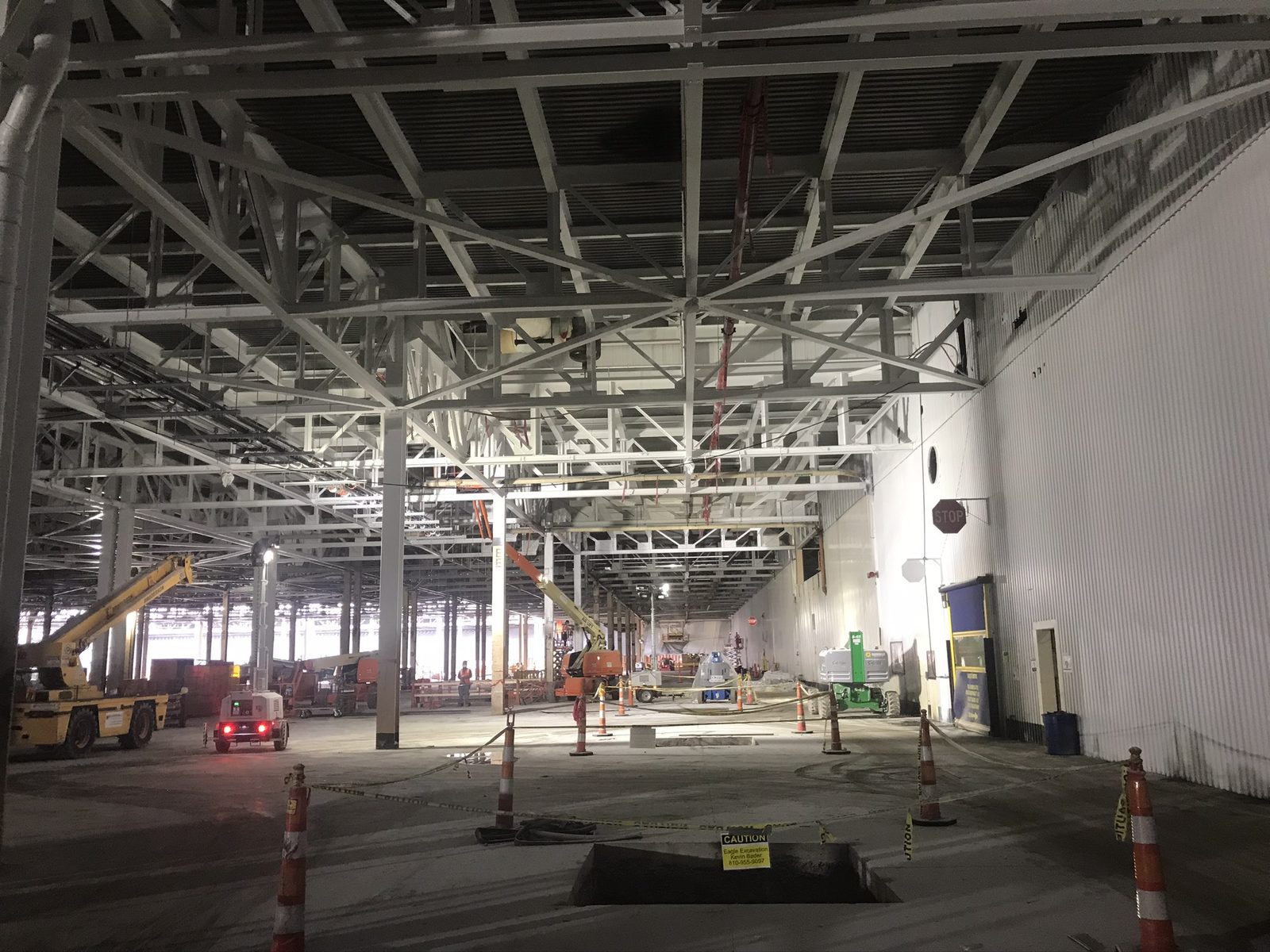 Cleared paint shop interior at Detroit-Hamtramck with white steel trusses and boom lifts staged for work